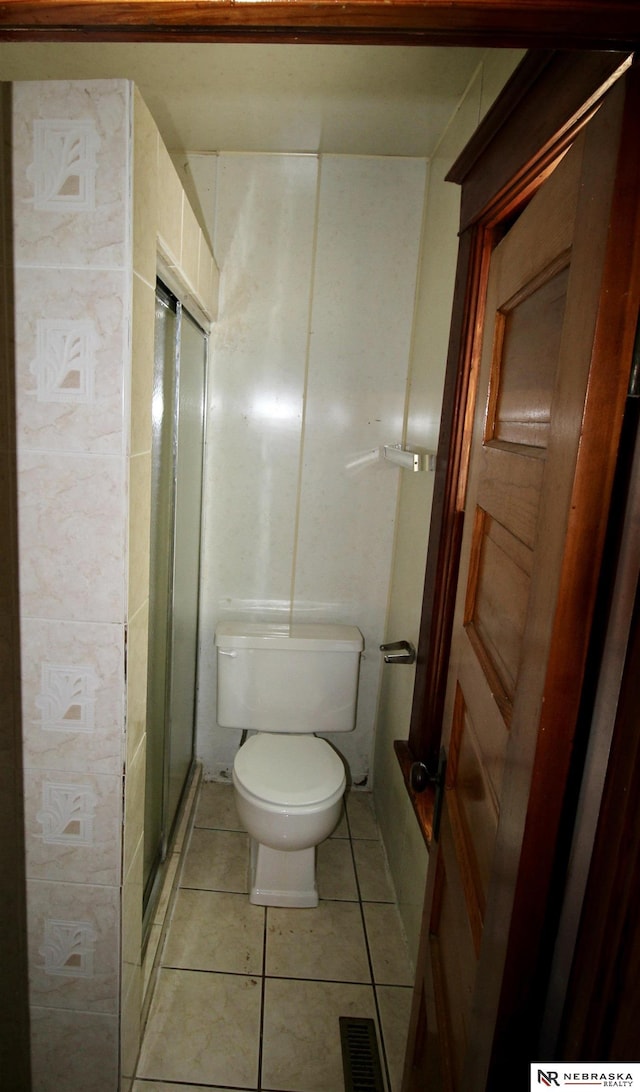 full bathroom featuring tile patterned flooring, toilet, a stall shower, and visible vents