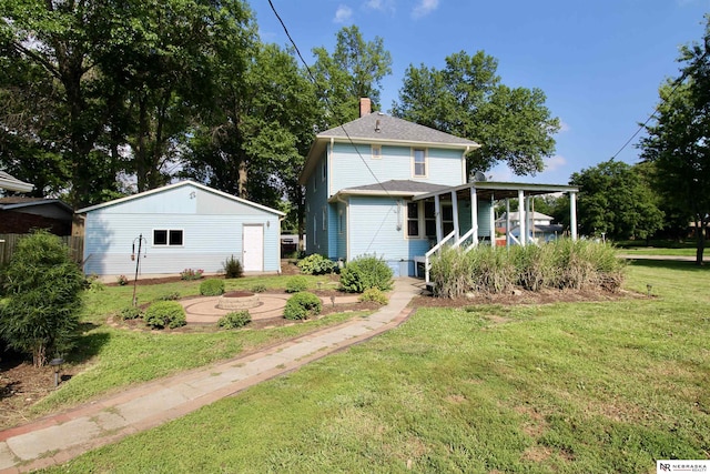 back of property with a lawn, a chimney, and an outdoor structure