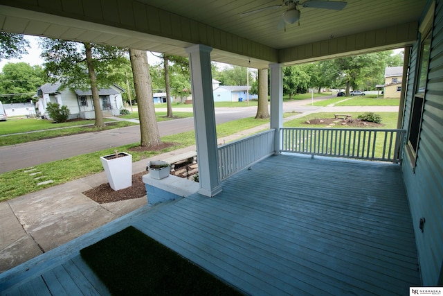 deck featuring a residential view, covered porch, and ceiling fan