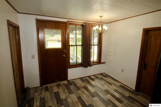 unfurnished dining area with dark wood-type flooring, a chandelier, and crown molding