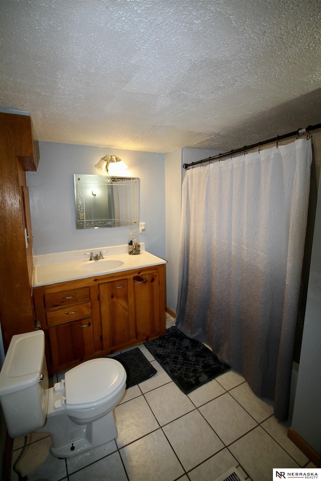 full bath featuring a textured ceiling, toilet, tile patterned flooring, and vanity