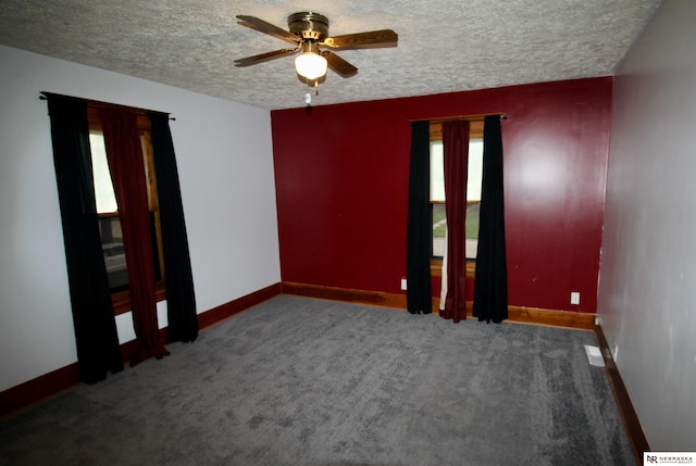 spare room featuring a ceiling fan, carpet floors, baseboards, and a textured ceiling