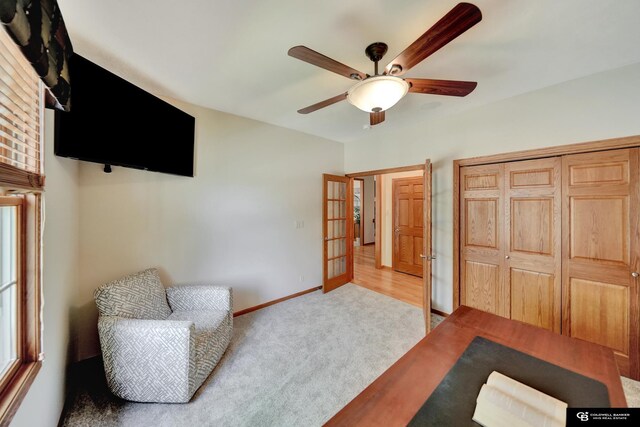 sitting room featuring a ceiling fan, carpet, and baseboards