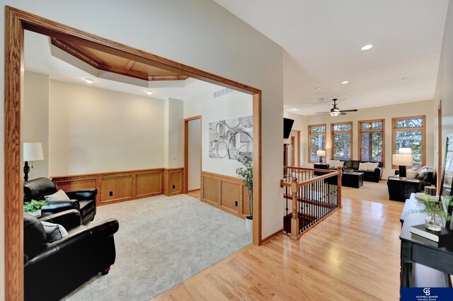 living room featuring a wainscoted wall, a ceiling fan, light wood-style flooring, recessed lighting, and a decorative wall