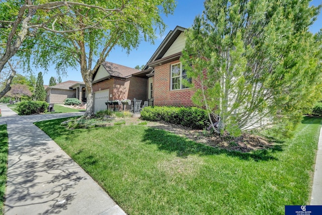 single story home with brick siding, an attached garage, a front yard, and driveway