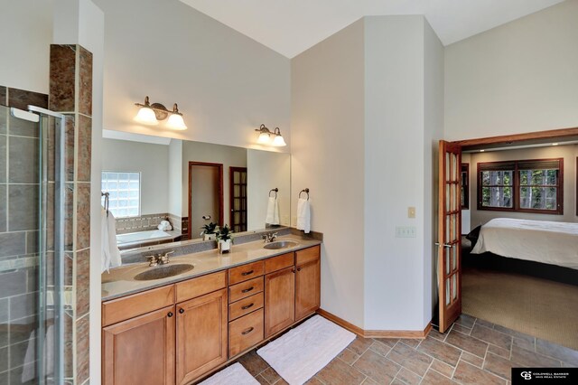 ensuite bathroom with a shower stall, a high ceiling, baseboards, a bath, and double vanity