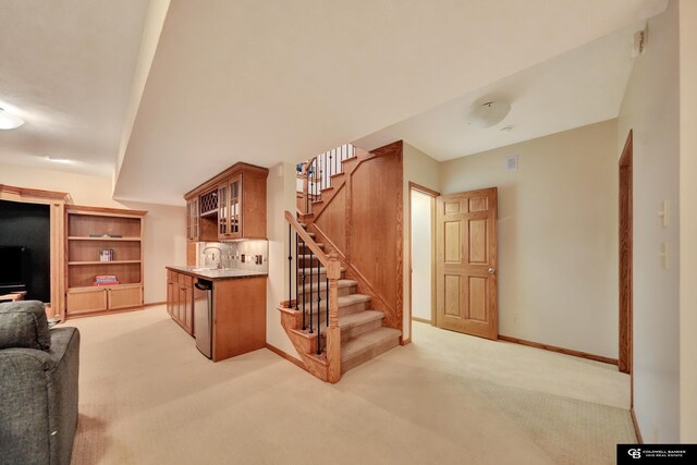 living room with stairway, light colored carpet, bar, and baseboards