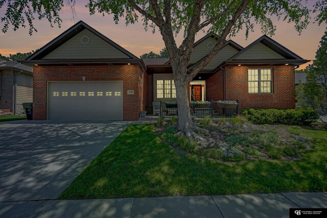 ranch-style home featuring brick siding, a garage, and concrete driveway
