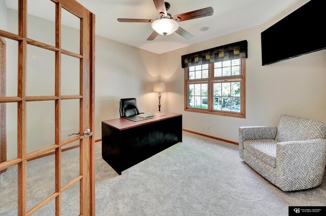 carpeted office space featuring baseboards and a ceiling fan
