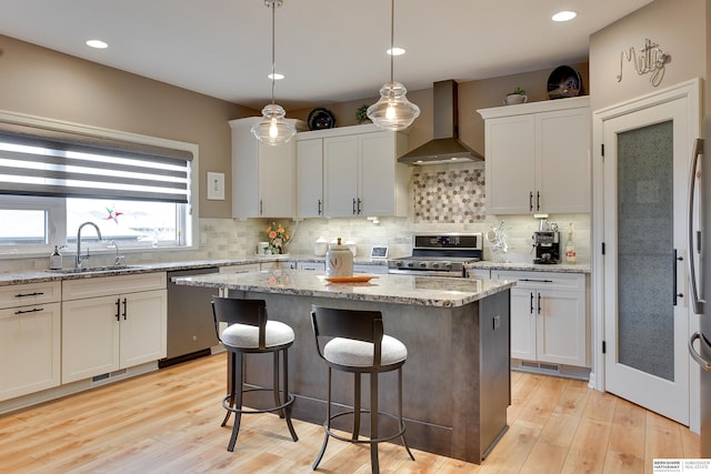 8914 N 171st St, Bennington, NE 68007 - kitchen with appliances with stainless steel finishes, wall chimney range hood, a sink, a center island, and tasteful backsplash