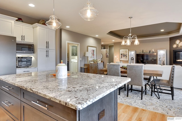 8914 N 171st St, Bennington, NE 68007 - kitchen featuring white cabinetry, light wood-style flooring, light stone countertops, pendant lighting, and recessed lighting