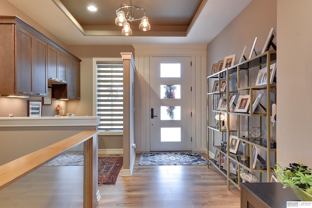 8914 N 171st St, Bennington, NE 68007 - foyer entrance with a tray ceiling, light wood-style flooring, a chandelier, and baseboards