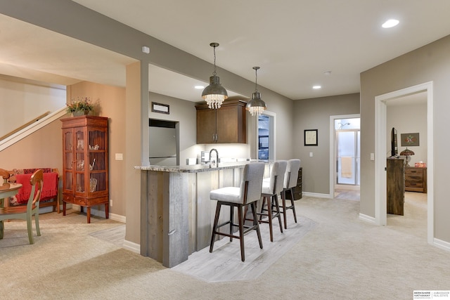 8914 N 171st St, Bennington, NE 68007 - kitchen featuring a breakfast bar area, light carpet, pendant lighting, recessed lighting, and baseboards