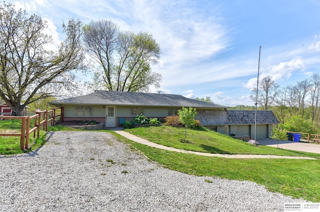 ranch-style house featuring fence, an attached garage, a front lawn, brick siding, and concrete driveway