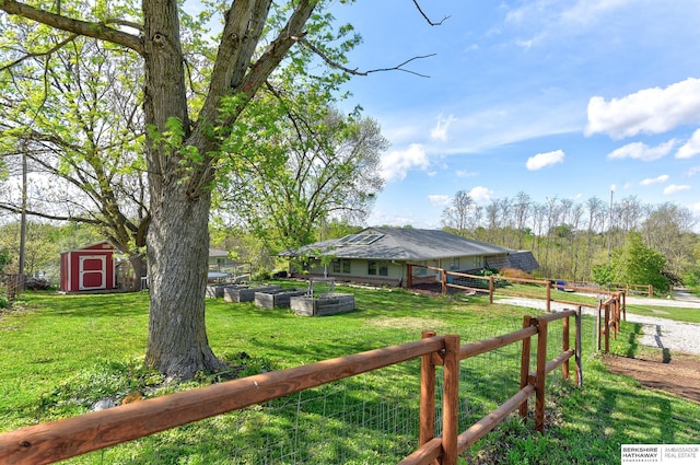 view of yard with a storage unit, an outdoor structure, and fence