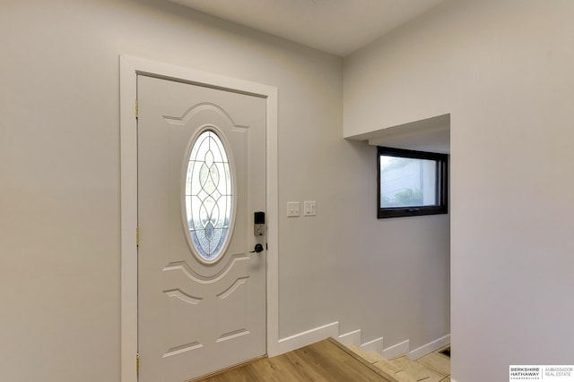 foyer entrance with baseboards and light wood finished floors