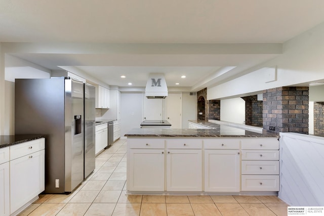 kitchen with light tile patterned flooring, dark stone counters, white cabinetry, tasteful backsplash, and appliances with stainless steel finishes
