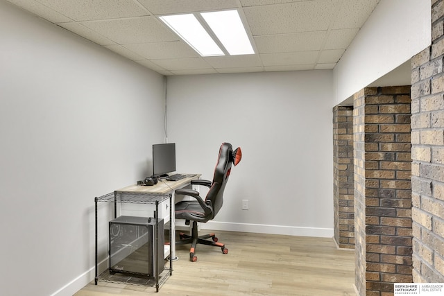 home office featuring baseboards, a drop ceiling, and wood finished floors