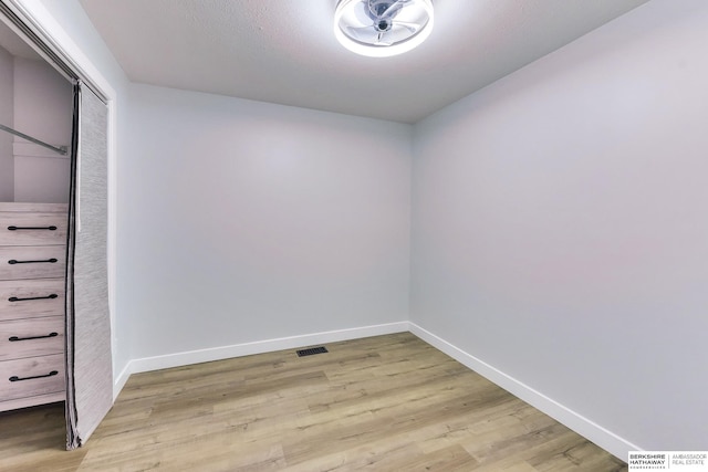 spare room featuring baseboards, light wood finished floors, and visible vents