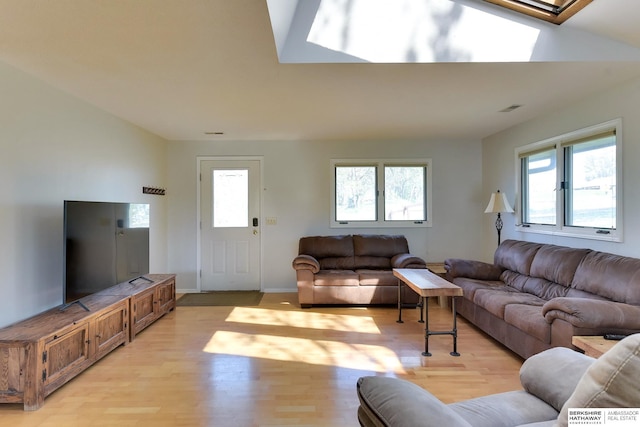 living room featuring a skylight, visible vents, and light wood-style floors