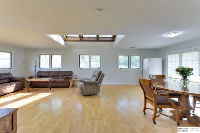 dining room with light wood-style floors, baseboards, and plenty of natural light