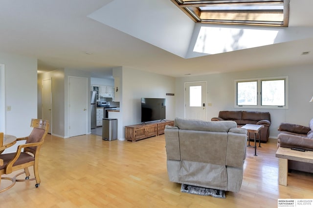 living room with light wood-style floors, baseboards, and a skylight