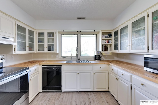 kitchen featuring wooden counters, visible vents, a sink, stainless steel appliances, and light wood-style flooring