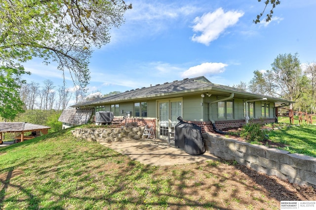 rear view of house featuring a lawn, central air condition unit, a patio area, and brick siding