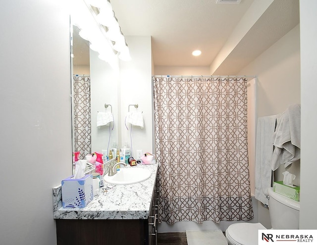 bathroom featuring toilet, vanity, shower / bath combo with shower curtain, and visible vents