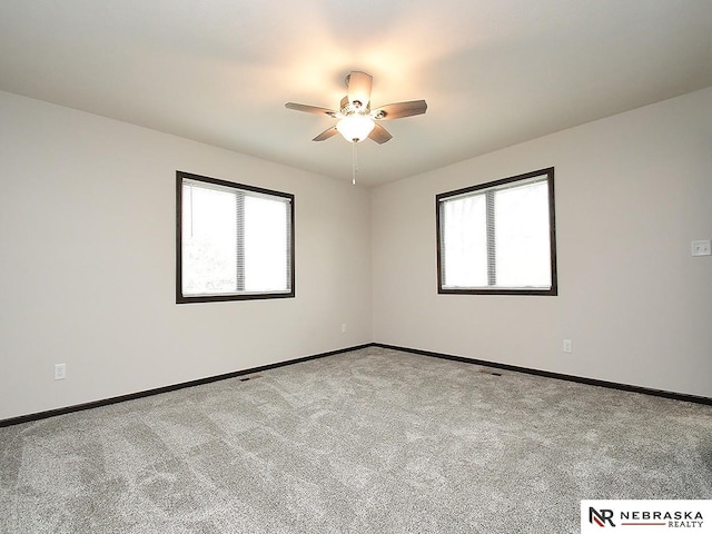 empty room featuring baseboards, carpet flooring, and a ceiling fan