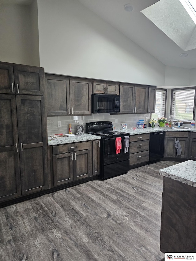 kitchen featuring high vaulted ceiling, dark brown cabinetry, tasteful backsplash, wood finished floors, and black appliances