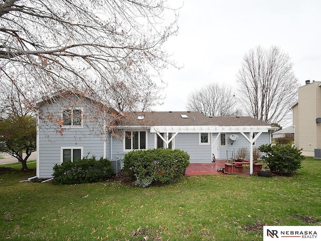 rear view of house with a patio, central AC, and a yard