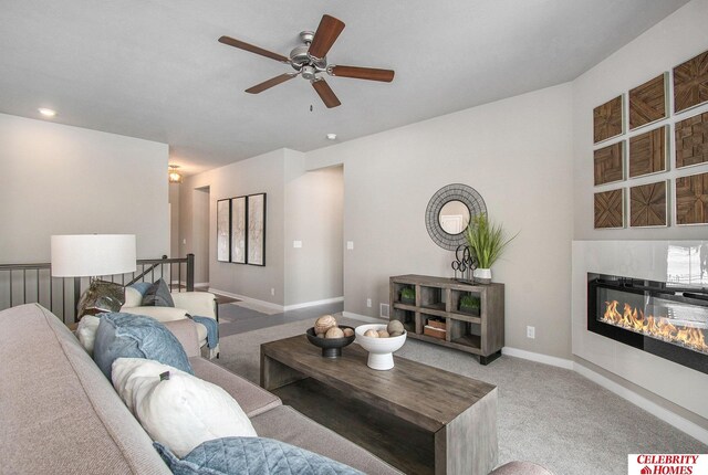 16935 Vernon Ave, Omaha, NE 68116 - living room featuring baseboards, ceiling fan, carpet flooring, and a glass covered fireplace