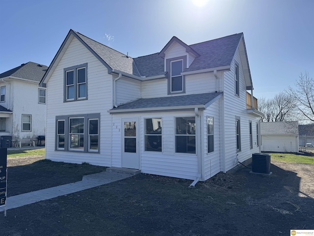 view of front of home featuring roof with shingles and central air condition unit