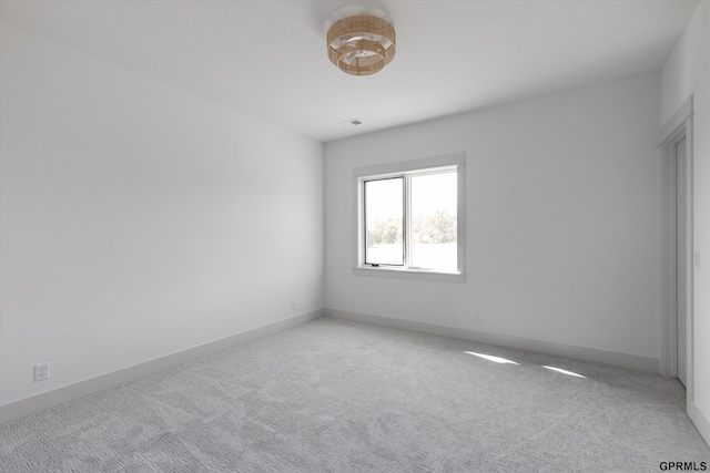 spare room featuring light carpet, baseboards, and visible vents