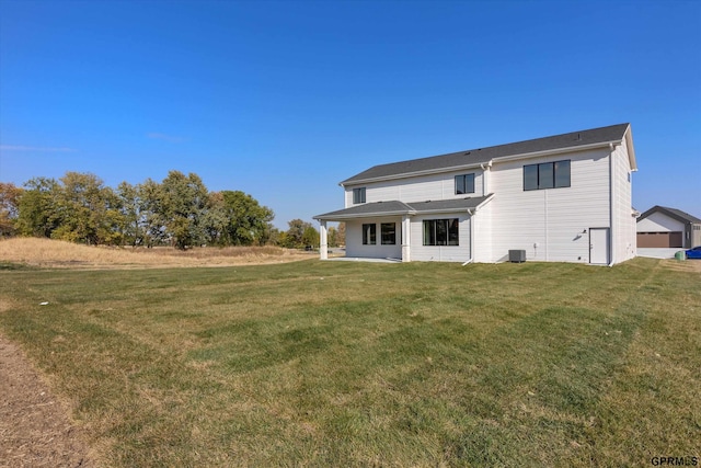 rear view of property featuring cooling unit and a yard