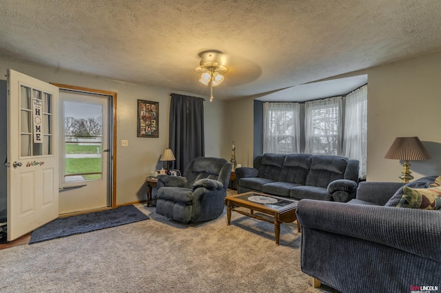 living area with carpet flooring, a textured ceiling, and ceiling fan