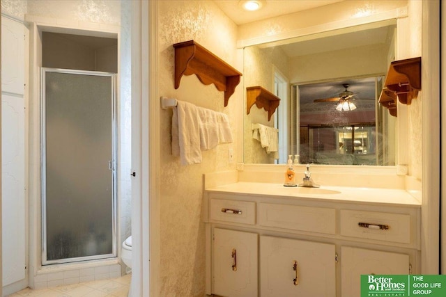 bathroom with toilet, a shower stall, ceiling fan, and vanity