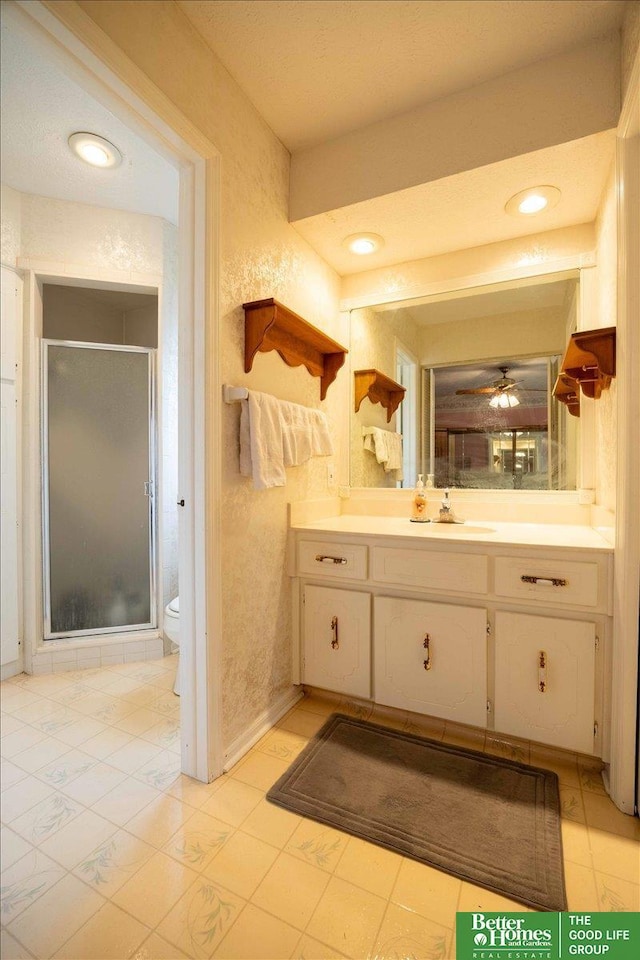 full bathroom featuring a shower stall, vanity, and toilet