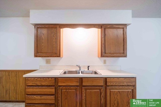 kitchen with light countertops, brown cabinets, and a sink