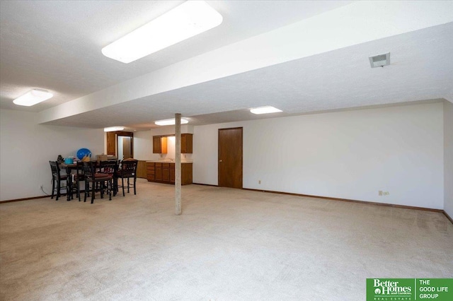 finished basement with light carpet, baseboards, and visible vents