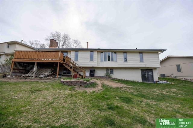 back of house with a deck, a lawn, fence, and stairs