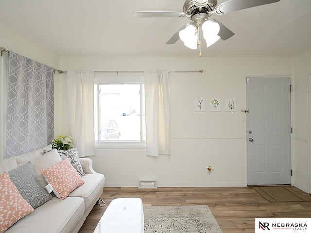 living room featuring baseboards, visible vents, ceiling fan, and wood finished floors