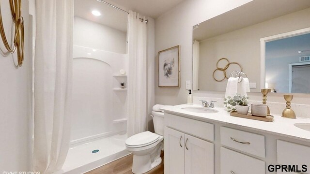 bathroom featuring visible vents, a shower stall, double vanity, toilet, and a sink