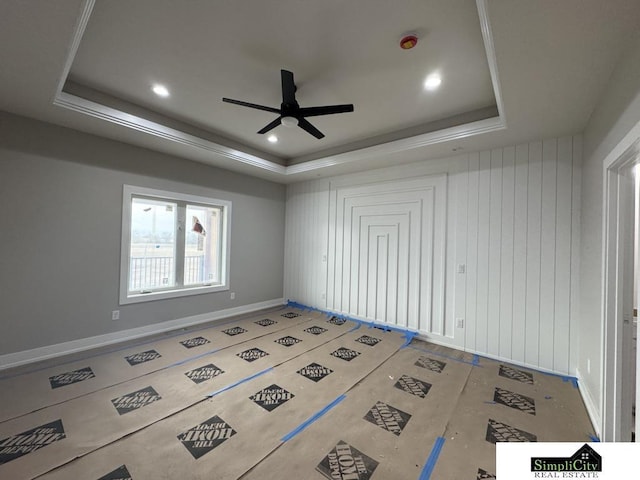 empty room featuring baseboards, a tray ceiling, recessed lighting, and ceiling fan