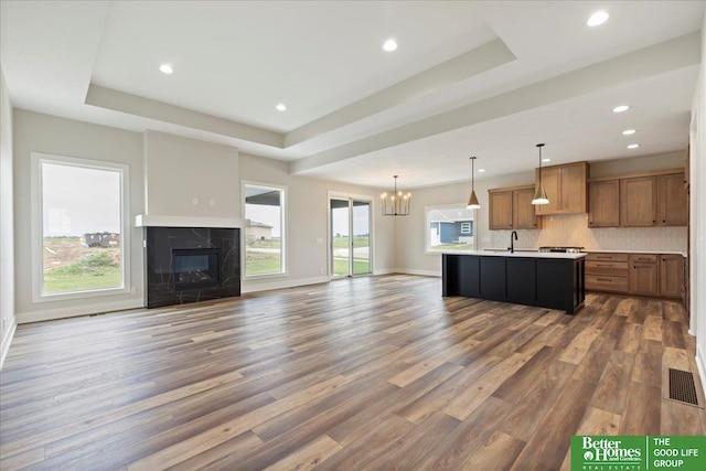 5924 N 208th St, Elkhorn, NE 68022 - kitchen with open floor plan, a sink, dark wood-type flooring, a raised ceiling, and brown cabinetry