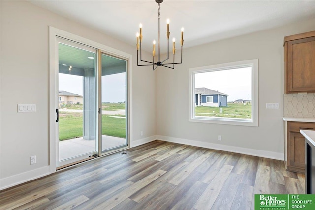 5924 N 208th St, Elkhorn, NE 68022 - unfurnished dining area featuring wood finished floors, a chandelier, and baseboards