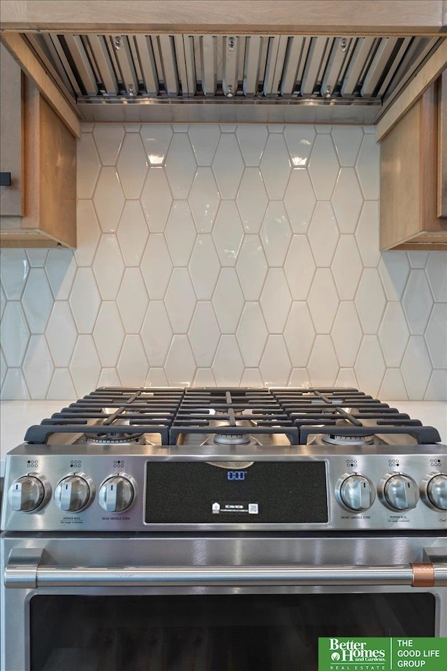 5924 N 208th St, Elkhorn, NE 68022 - detailed view of gas range, tasteful backsplash, brown cabinets, and exhaust hood