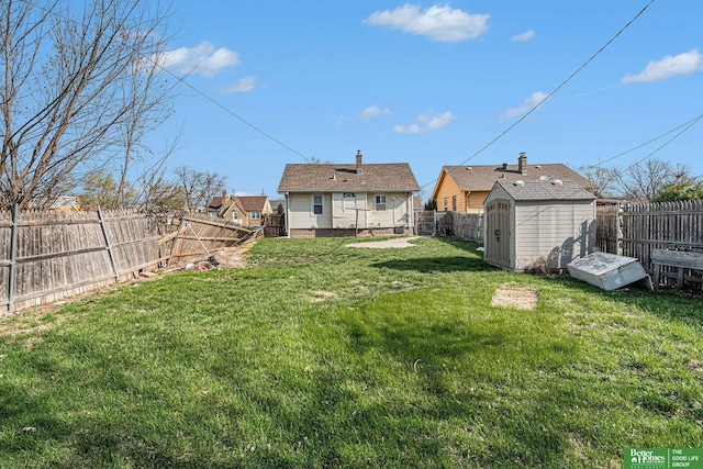 view of yard with a fenced backyard, an outdoor structure, and a storage shed