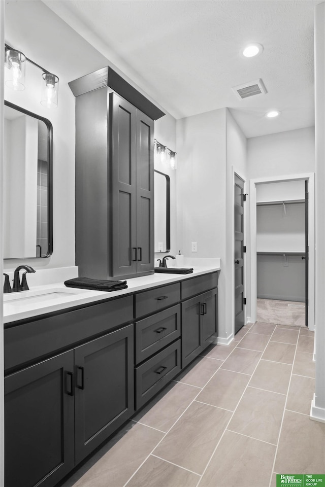 full bath featuring tile patterned flooring, double vanity, visible vents, and a sink